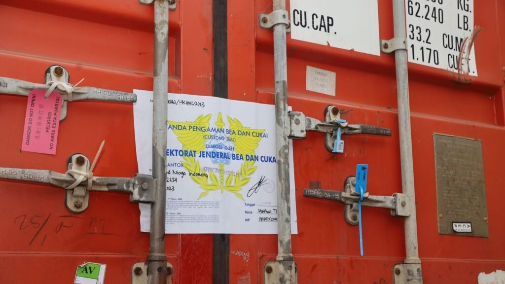 High-security bolt seal being locked onto a shipping container, symbolizing the start of a secure transit.