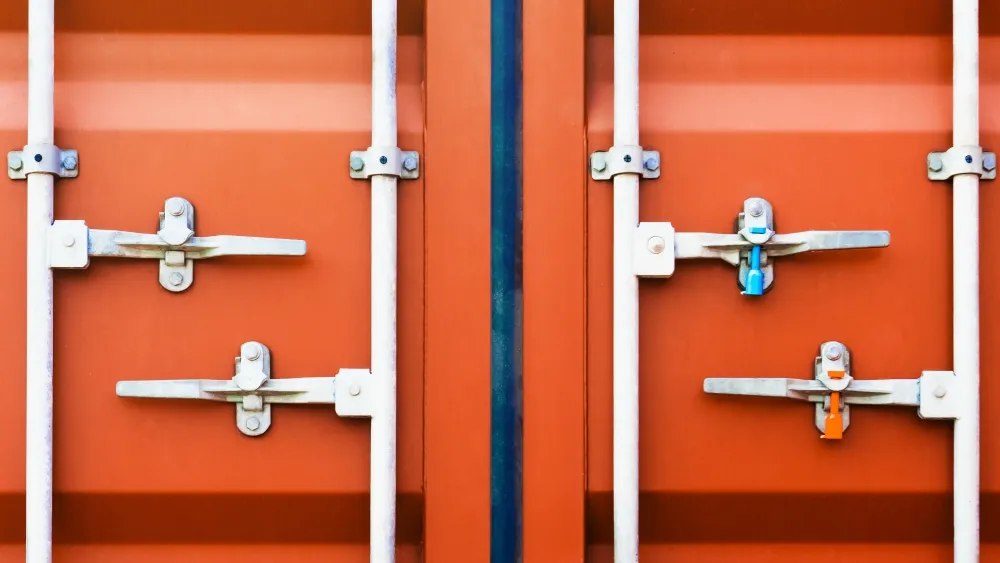 An image of a shipping container with a compliant seal, with a stylized passport stamp graphic overlaid on it