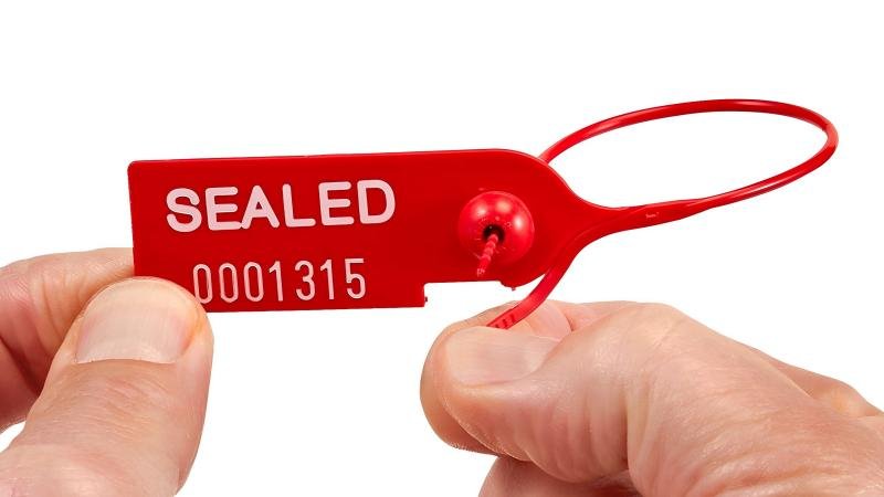 A close-up of a broken plastic seal, clearly showing it has been snapped, leaving no ambiguity about its status.
