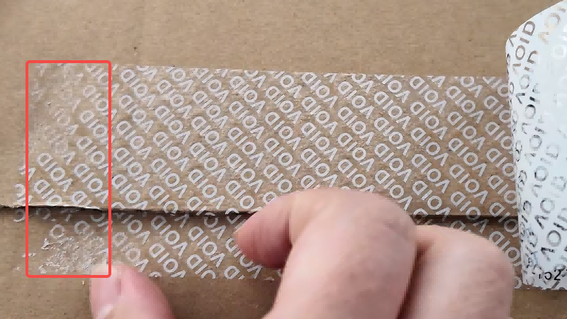 trying and failing to wipe away the strong "VOID" adhesive residue from a cardboard box