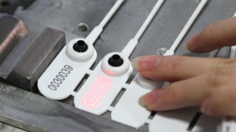 A close-up shot showing the unique laser-engraved serial number on a security seal