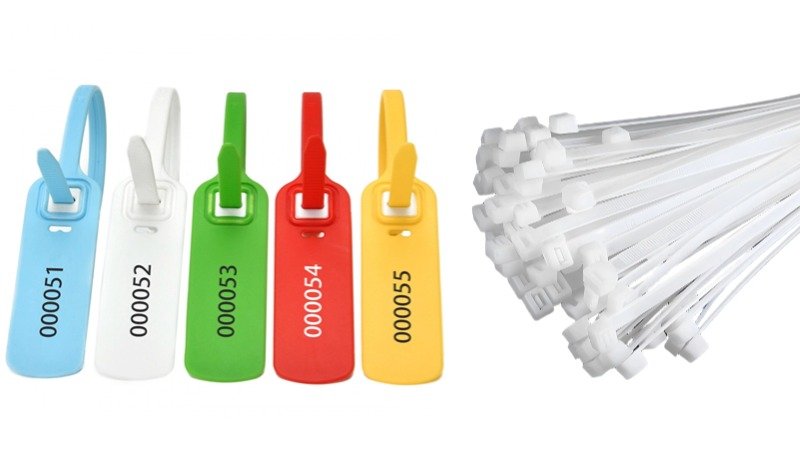 A standard white zip tie next to a uniquely numbered plastic security seal for clear comparison