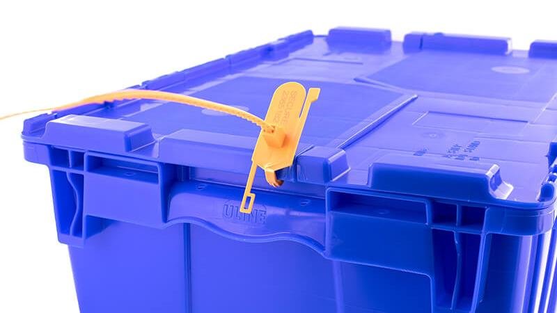 A close-up of a PP seal securing the lock on a hospital medicine cabinet or an airline catering cart.