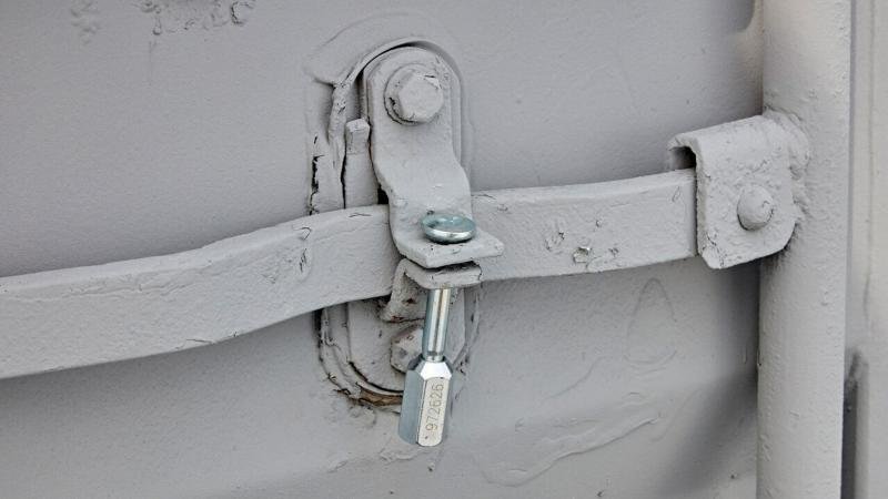 Container Bolt Seal for Compliance A heavy-duty container bolt seal, clearly showing its serial number, securely fastened on a container's locking bars.