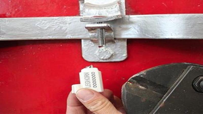 A bolt cutter about to snap a bolt seal, emphasizing the necessary act of destruction to gain entry.