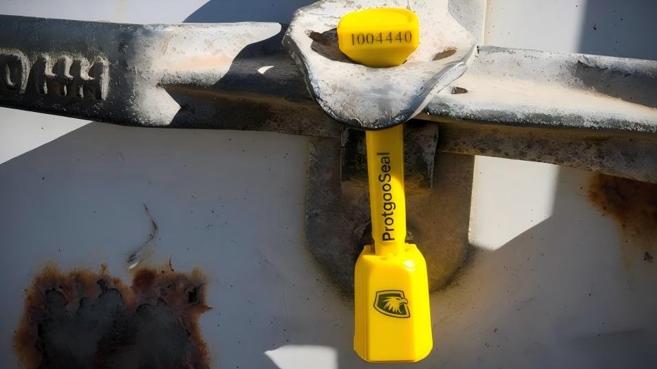 A bolt seal with a complex logo laser-etched onto the body, showing clear branding.