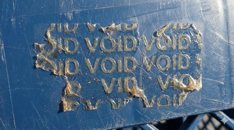 Close up macro shot of the sticky VOID residue left on a plastic surface