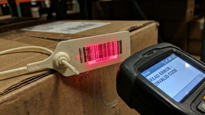 Scanner failing to read a fuzzy, counterfeit barcode on a fake plastic seal